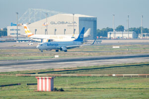 Aviones en el aeropuerto de San Joan con edificio de mantenimiento al fondo