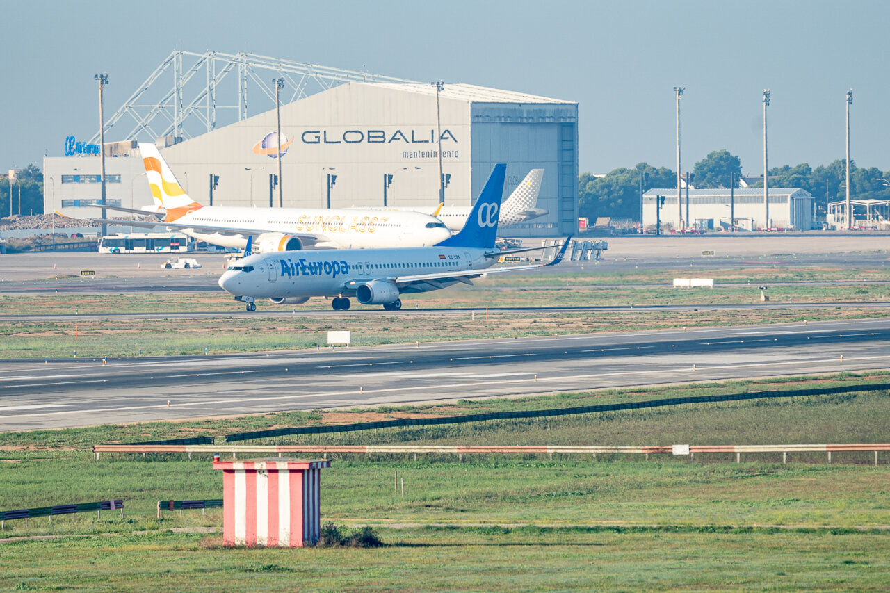 Aviones en el aeropuerto de San Joan con edificio de mantenimiento al fondo