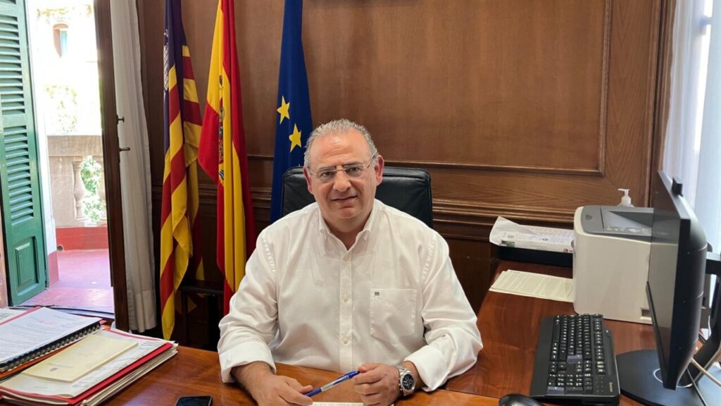 Alfonso Rodríguez en su oficina con banderas de España y Europa