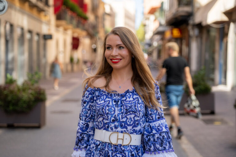 Alisa Selishchava sonríe en una calle de Mallorca con un vestido azul