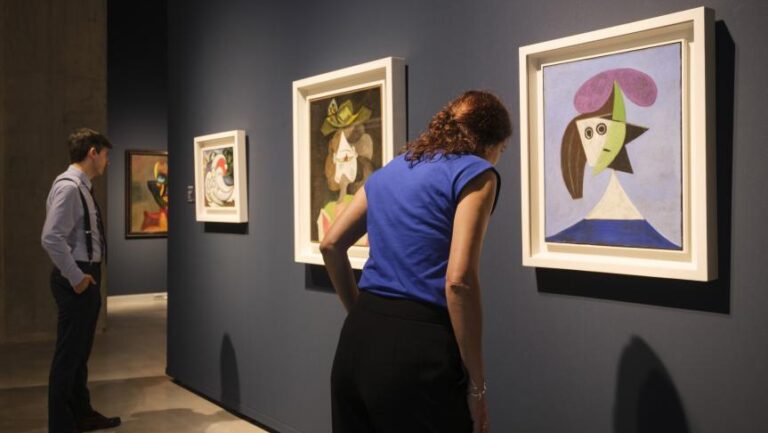 Visitantes observando obras en la exposición de arte biomórfico