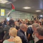 Multitud de personas en el aeropuerto de Barajas celebrando la llegada de activistas.