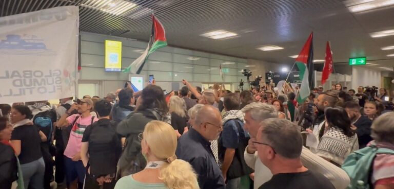 Multitud de personas en el aeropuerto de Barajas celebrando la llegada de activistas.