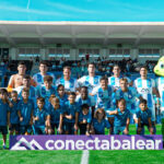 Equipo del Atlético Baleares posando en el campo con su mascota