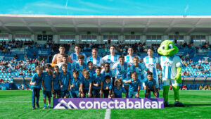 Equipo del Atlético Baleares posando en el campo con su mascota
