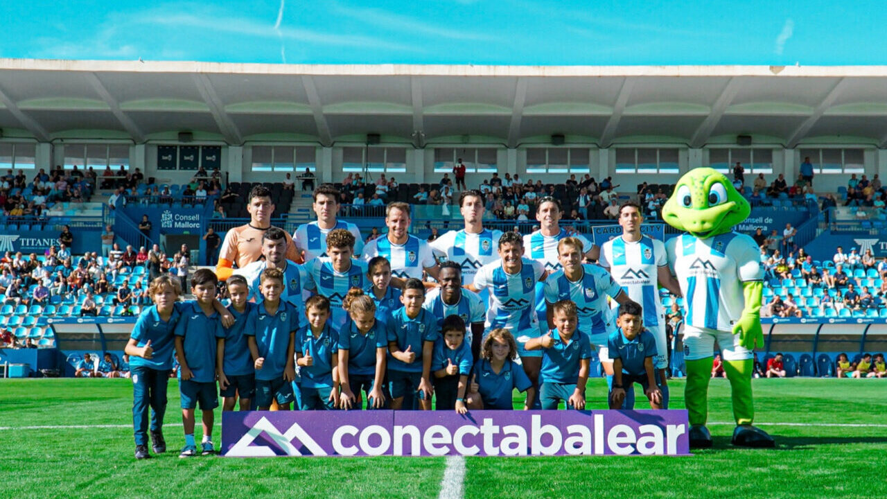 Equipo del Atl&eacute;tico Baleares posando en el campo con su mascota