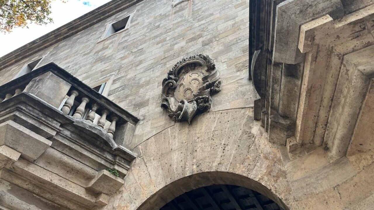 Edificio con detalles arquitectónicos y escudo en la fachada