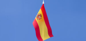 Bandera de España ondeando en un cielo azul claro