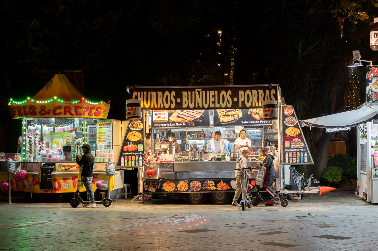 Puesto de buñuelos y churros en una feria nocturna