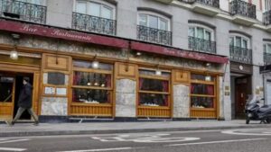 Fachada del emblemático Café Gijón en Madrid con un transeúnte.