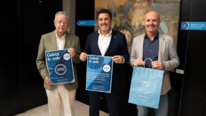 Tres hombres sosteniendo carteles de la campaña Calvià lo Vale