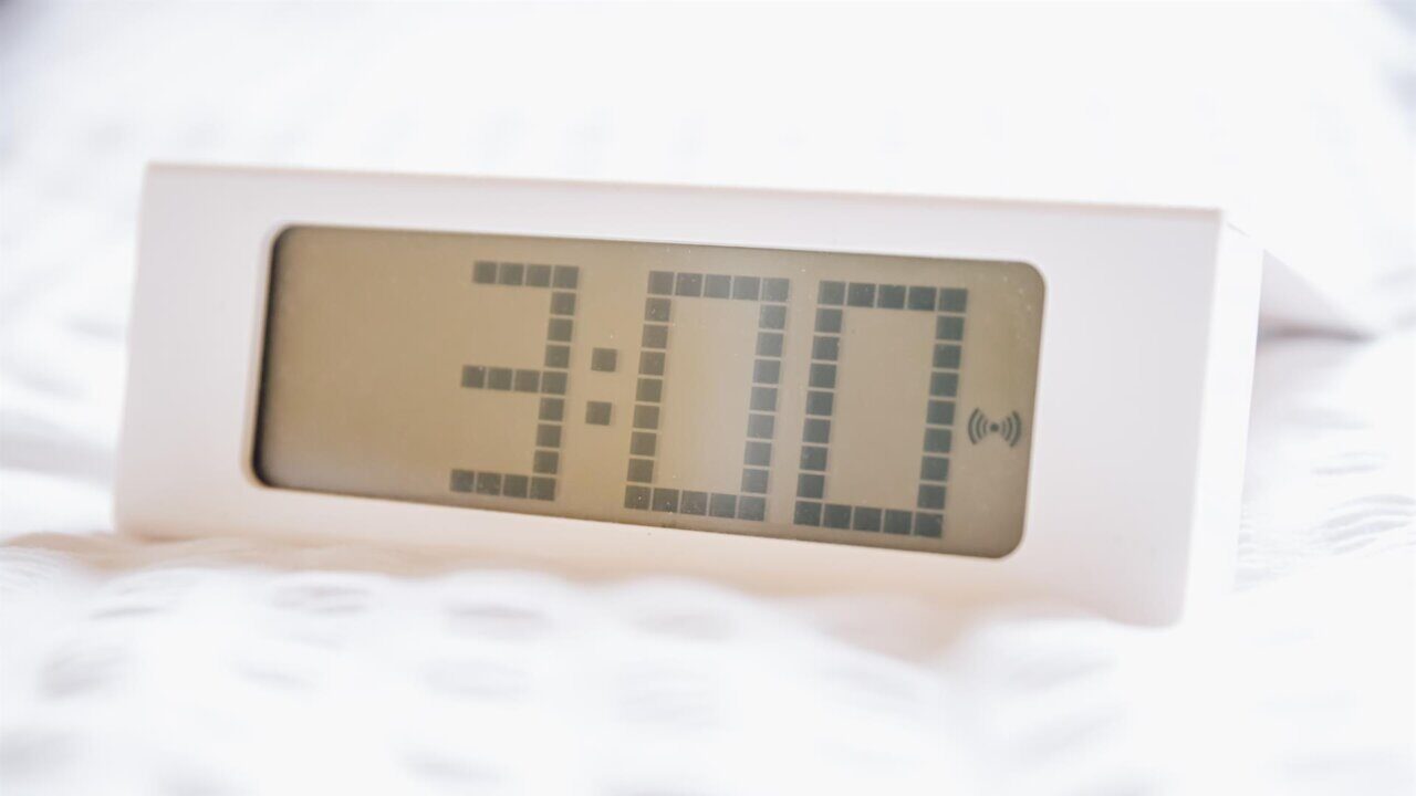 Reloj digital mostrando la hora 3:00 en un fondo claro