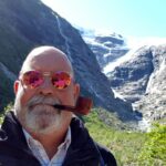 Hombre con pipa en un paisaje montañoso con glaciares