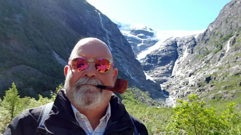 Hombre con pipa en un paisaje montañoso con glaciares
