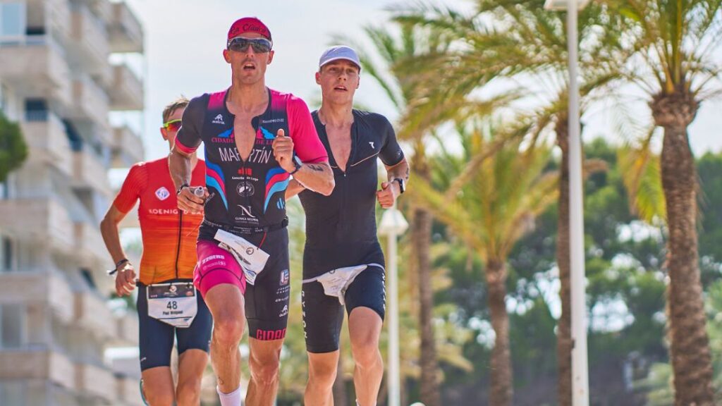 Atletas corriendo en el Challenge Peguera Mallorca rodeados de palmeras