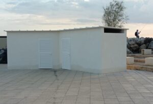 Caseta blanca en el paseo del Molinar con puertas de persiana.