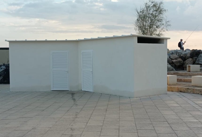 Caseta blanca en el paseo del Molinar con puertas de persiana.