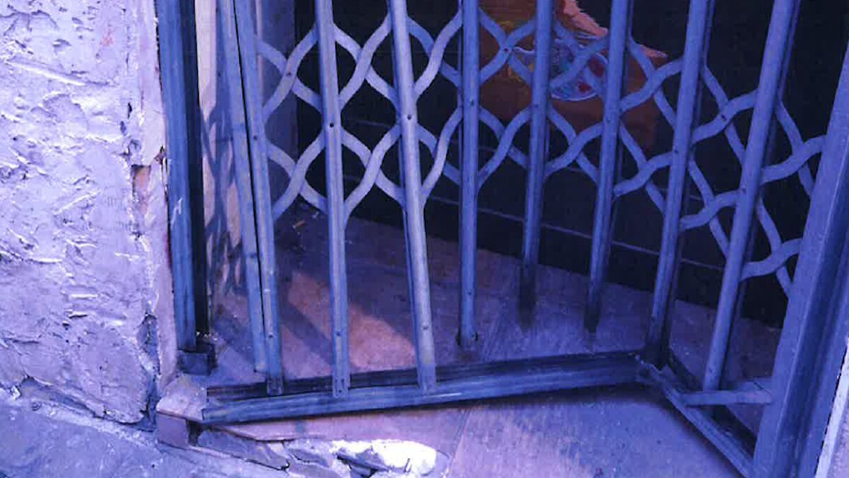 Puerta dañada de un local en Palma tras ocupación ilegal.