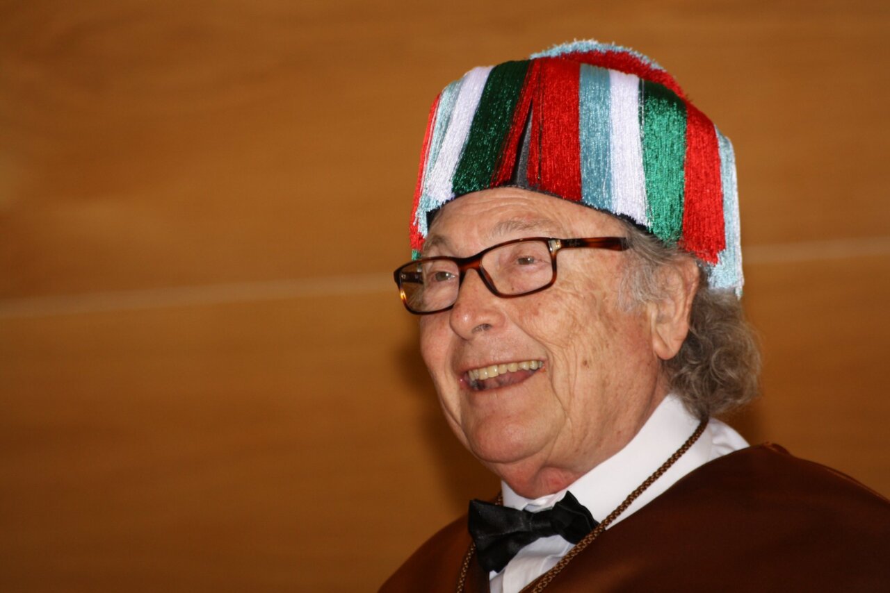 Eduard Punset sonriendo con un gorro colorido en un evento
