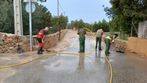 Efectivos de emergencias limpiando una calle en Ibiza tras fuertes lluvias