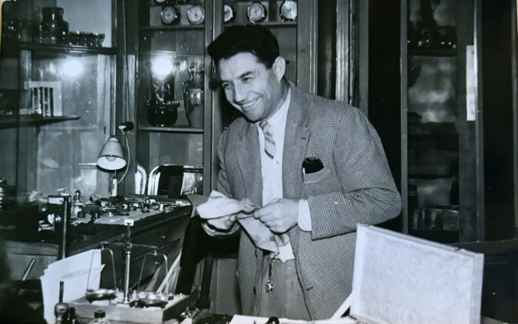 Hombre sonriendo en una tienda con joyas y herramientas