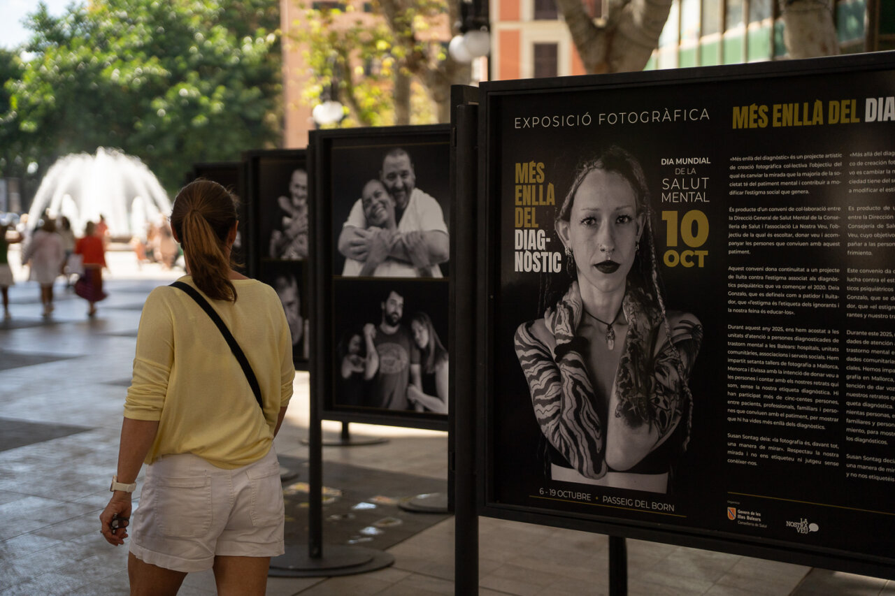 Persona observando una exposici&oacute;n sobre salud mental en la calle.
