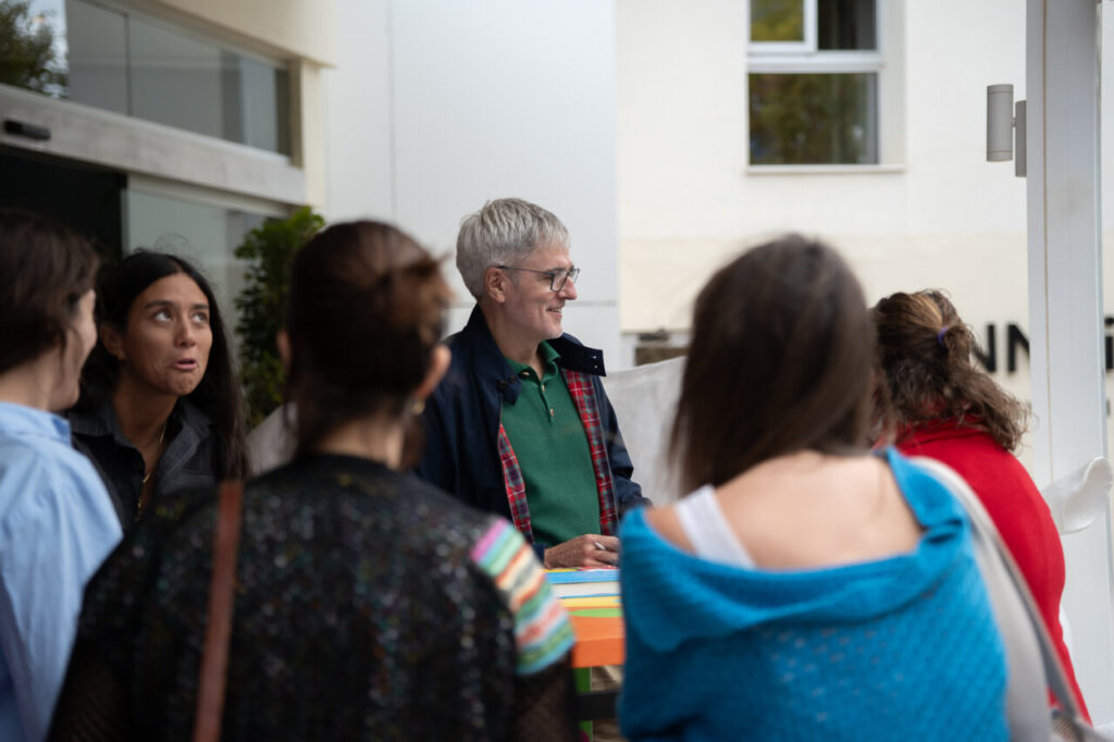 Encuentro literario en el Festival FLEM con participantes y un autor.