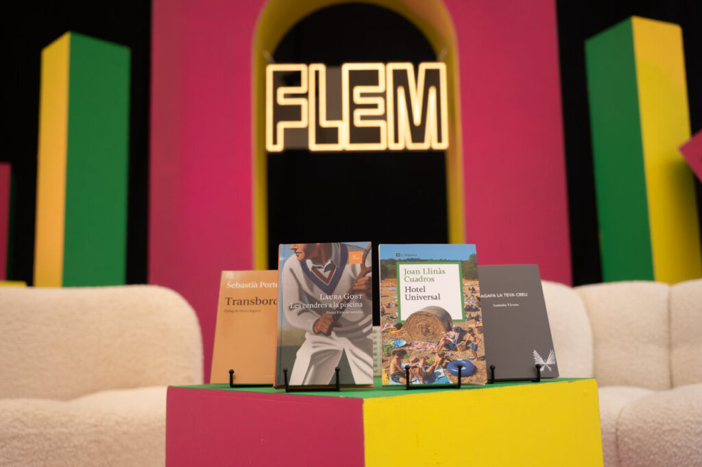 Libros expuestos en el festival FLEM con un fondo colorido