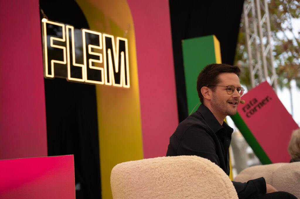 Participante en el festival FLEM en Magaluf, con fondo colorido.