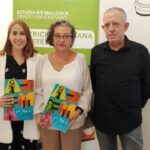 Tres personas posando con documentos en un evento de colaboración