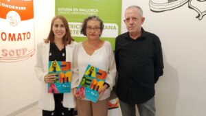 Tres personas posando con documentos en un evento de colaboración