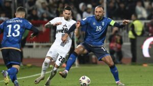 Jugadores de Kosovo y Eslovenia compiten por el balón en un partido de fútbol.