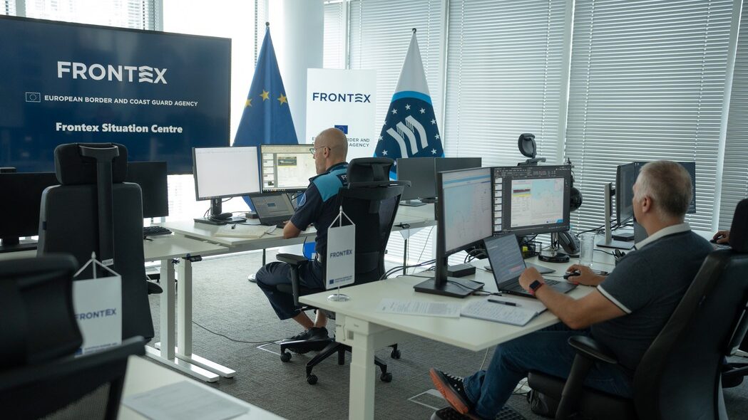 Oficina de Frontex con personal trabajando en monitores