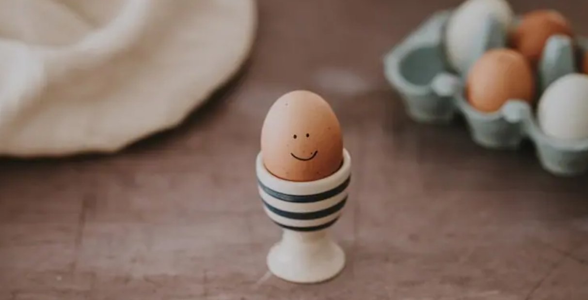 Huevo con cara sonriente en un soporte de cerámica