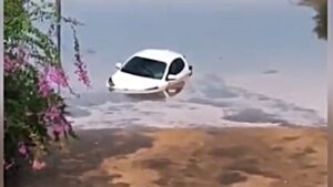 Coche blanco parcialmente sumergido en agua tras fuertes lluvias en Ibiza