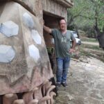 Joan Balaguer posando en su casa junto a una obra de arte.