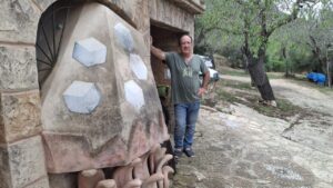 Joan Balaguer posando en su casa junto a una obra de arte.