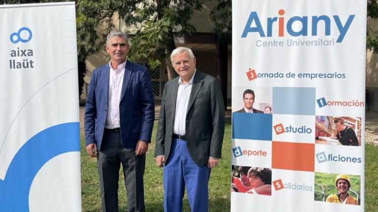 Dos hombres posando junto a pancartas del Centre Universitari Ariany y Aixa-Llaüt.