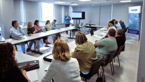Reunión formativa sobre fugas estructurales de agua con participantes atentos.