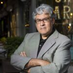 Juan Manuel de Prada posando en un entorno urbano con brazos cruzados