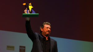 Julio Medem sosteniendo un premio en el festival Evolution