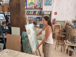 Karina Cappato organizando su obra en el estudio de pintura.