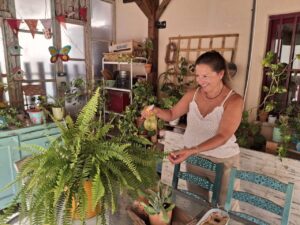 Karina Cappato cuidando plantas en su taller decorado