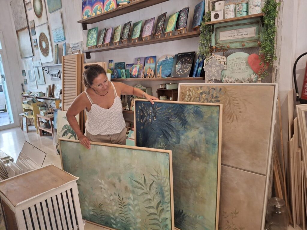 Karina Cappato elige una pintura en su estudio lleno de arte.