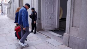 Koldo García saliendo del tribunal con un policía y una mujer