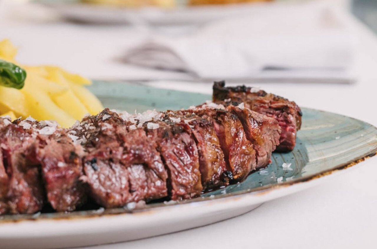 Plato de carne asada con guarnición de patatas en Los Rafaeles