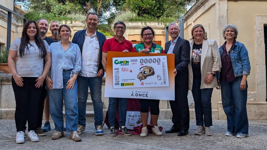 Grupo de personas sosteniendo un cupón de la ONCE con una máscara de dimoni