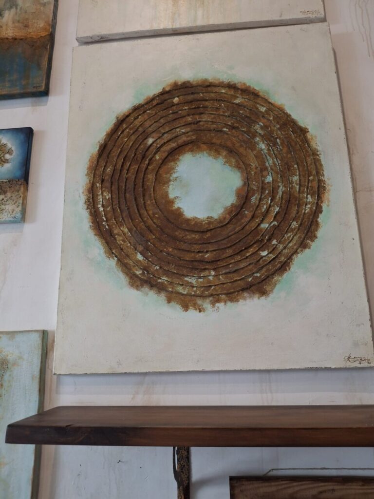 Obra de arte abstracta con c&iacute;rculos en tonos marrones y azules.