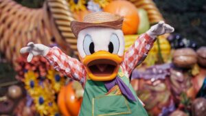 Pato Donald vestido con un sombrero y ropa colorida en un entorno festivo