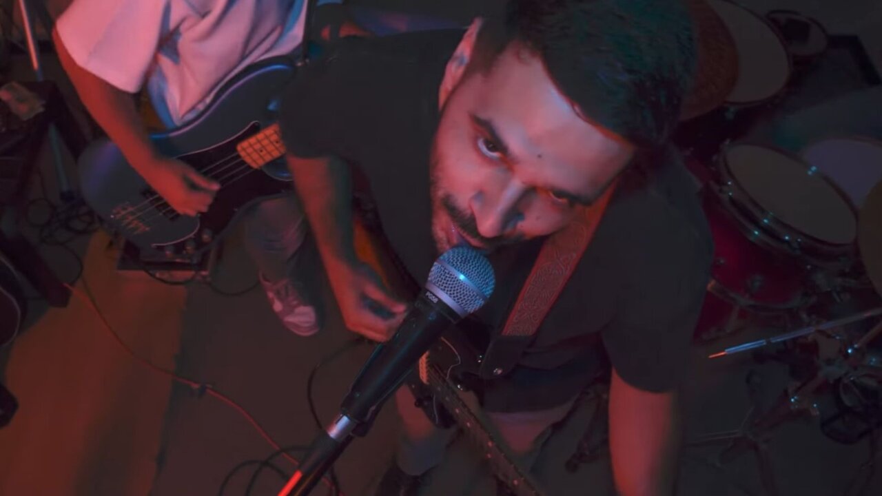 Pepto de Kamikazes cantando en un escenario con su banda.